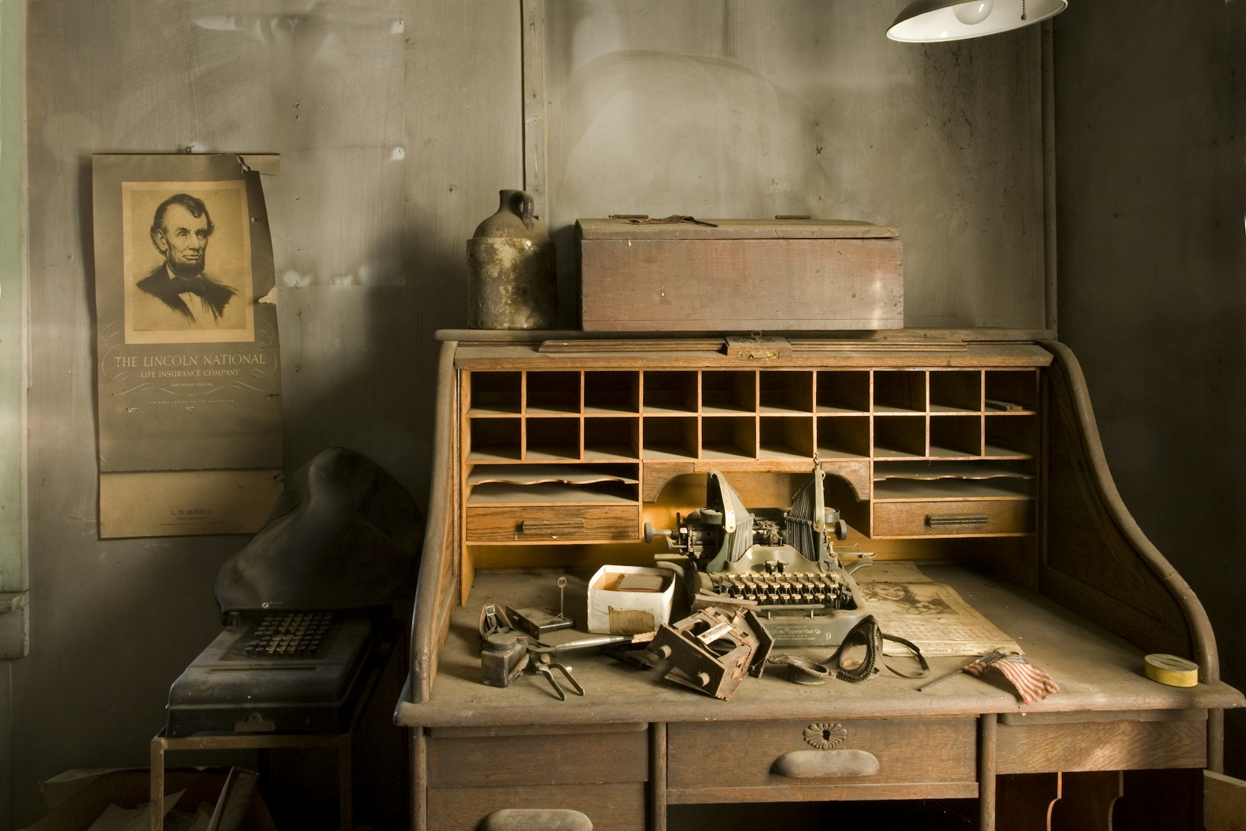 A 1940s wooden desk with an old typewriter and scattered papers